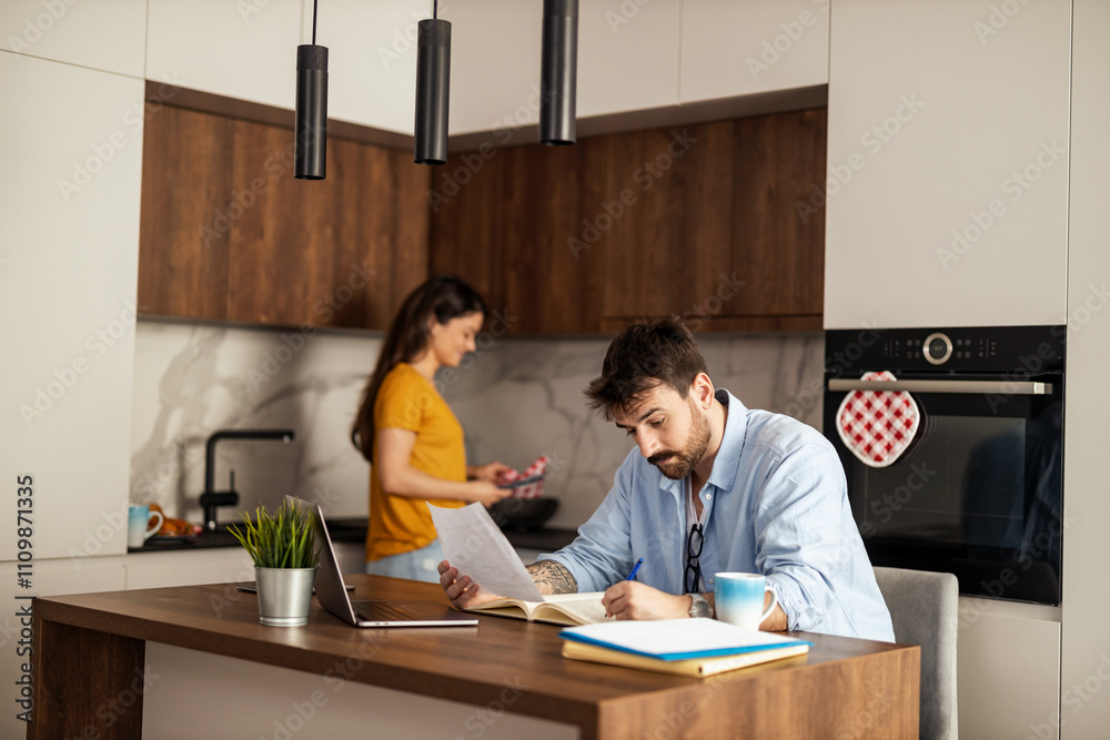 Couple Balancing Work and Home Life in Modern Kitchen Couple Balancing Work and Home Life in Modern Kitchen