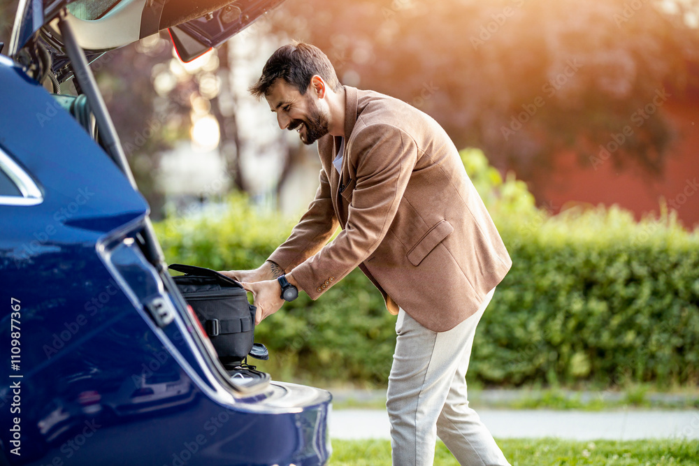 Man Loading Luggage Into Car Trunk Outdoors Man Loading Luggage Into Car Trunk Outdoors