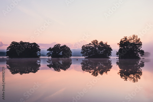 Four islands reflected in pastel color calm lake water