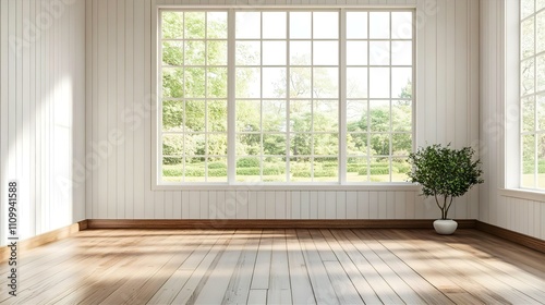 Bright, airy room with large windows overlooking a lush green garden, showcasing light hardwood floors and white paneled walls, a small potted plant adds a touch of nature.