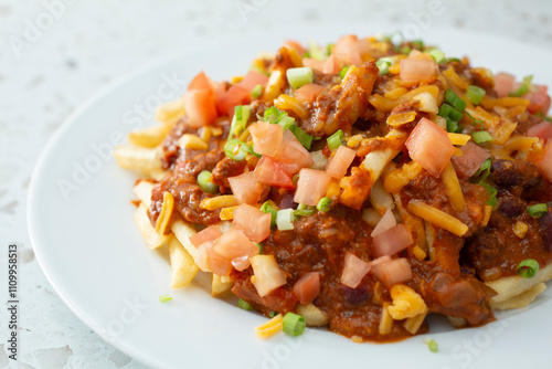 A view of a plate of chili cheese fries.