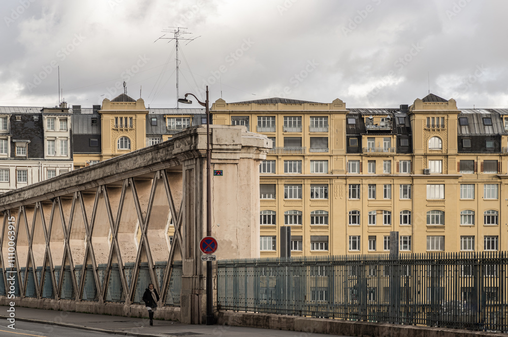 People walking along a Bridge on Rue La Fayette. Bridge built above the railways of gare de l'Est.