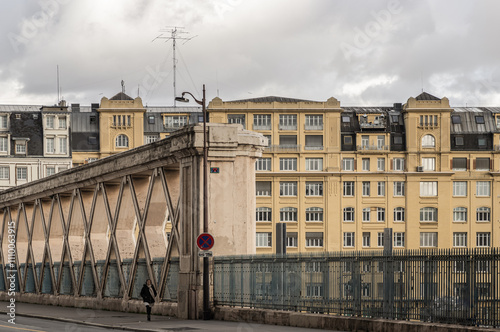 People walking along a Bridge on Rue La Fayette. Bridge built above the railways of gare de l'Est.