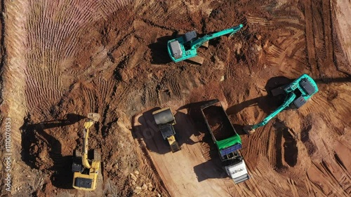 Aerial view road motor grader flatting dirt road surface, Motor grader road construction grader industrial machine construction site new road, Aerial view group excavator working on construction site.