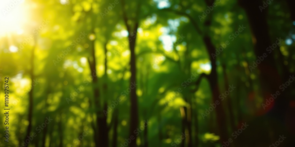 Fototapeta premium Sunbeams filtering through a lush canopy of trees creating a blurred background of greens and yellows