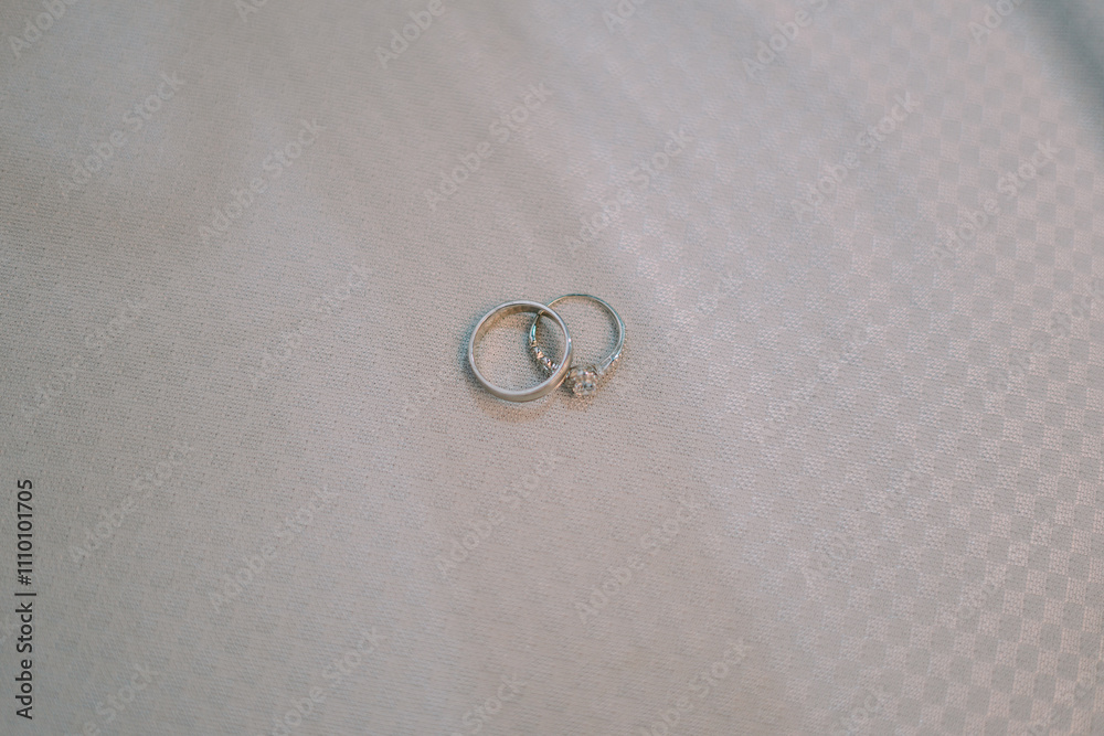 A wedding ring elegantly placed on a soft white fabric background, symbolizing love and commitment A wedding ring elegantly placed on a soft white fabric background, symbolizing love and commitment