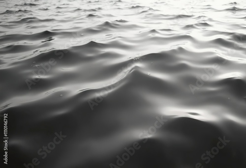 Choppy water surface with waves and ripples, creating a moody, monochrome texture