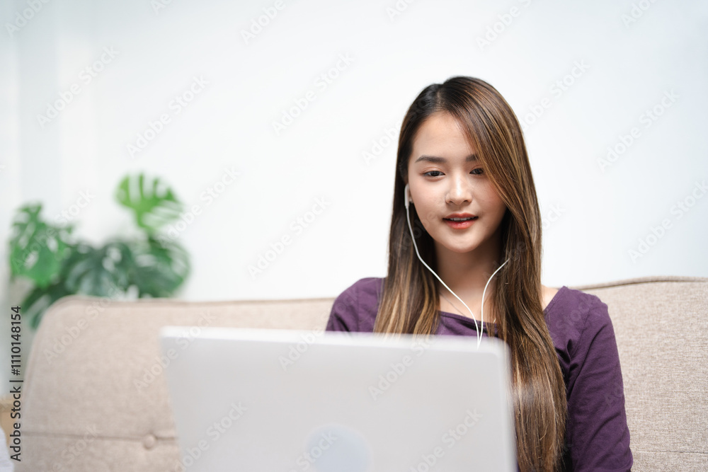 young asian female in earphones writing and taking note look at laptop screen study online on gadget. Happy female in earphones work distant on computer. Education concept. young asian female in earphones writing and taking note look at laptop screen study online on gadget. Happy female in earphones work distant on computer. Education concept.