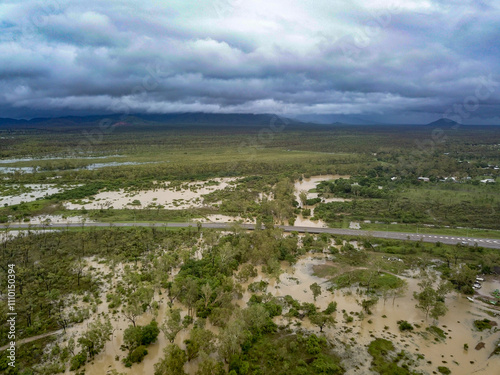 Aerial view of flooded town and river with brown floodwater, Townsville, Queensland