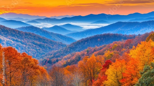 Vibrant autumn landscape at sunrise with foggy hills and colorful foliage under a dramatic orange sky and mountain panorama