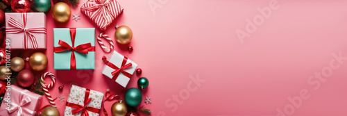 Christmas gifts and ribbons, surrounded by Christmas balls, lollipops on bright pink background. Christmas holiday spirit