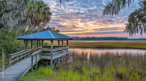 Scenic Dock at Sunset with Reflections Over Marshland Under a Colorful Sky