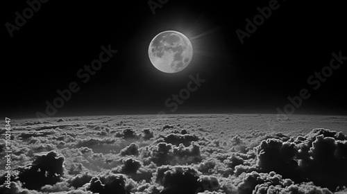 Mystical full moon illuminating cloudy night sky above a serene landscape with soft cloud layers and dramatic monochrome contrast photo