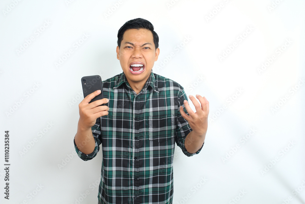 furious asian man shouting while holding cellphone and raising his hand show angry face isolated on white background furious asian man shouting while holding cellphone and raising his hand show angry face isolated on white background