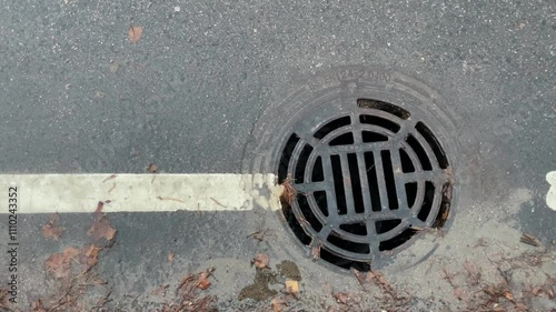 Urban Drain Cover Featuring Ripples on a Rainy Pavement Scene in the City Environment
