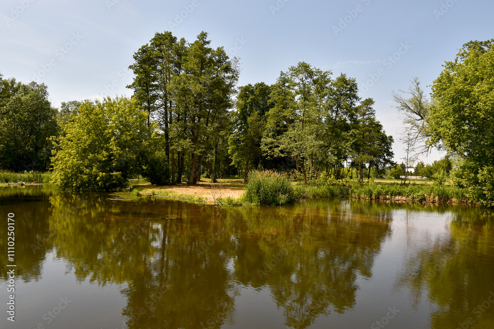 Scenic Summer Landscape with Calm River and Lush Greenery in Poland Scenic Summer Landscape with Calm River and Lush Greenery in Poland