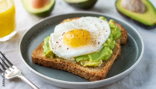 Avocado Toast with Fried Egg: A delectable breakfast or brunch featuring creamy avocado spread on toasted bread, topped with a perfectly fried egg. A healthy and visually appealing meal.