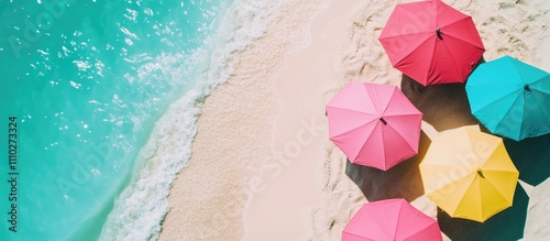 Tropical beach scene with colorful umbrellas casting shadows on sandy shore and vibrant turquoise ocean waves in background during summer vacation.