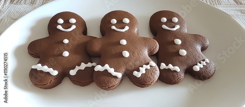 Homemade gingerbread cookies shaped like cheerful gingerbread men on a white plate ready for a festive occasion