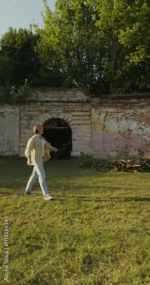 Three young friends are having fun and running around the ruins of a historic building. The fortress walls are overgrown with green vegetation. A sunny summer day Three young friends are having fun and running around the ruins of a historic building. The fortress walls are overgrown with green vegetation. A sunny summer day