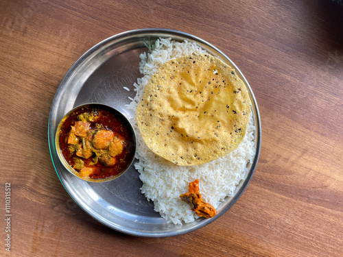 Fish curry thali served with papad photo