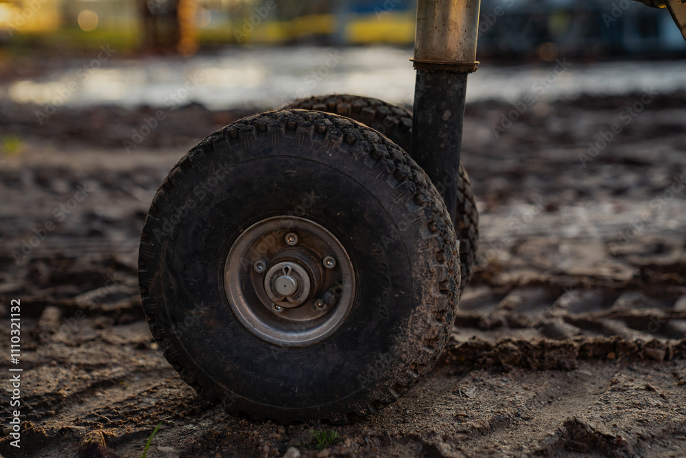 Small construction trailer tires on rough ground in autumn Small construction trailer tires on rough ground in autumn