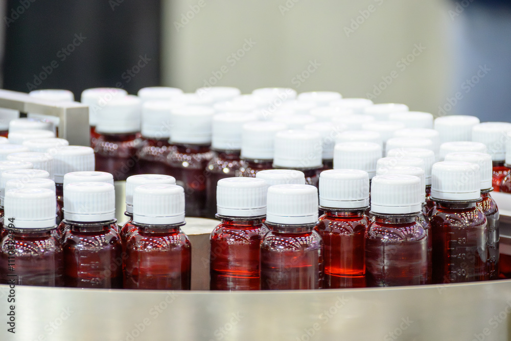 The red drug bottles on the conveyor belt for filling process. The red drug bottles on the conveyor belt for filling process.