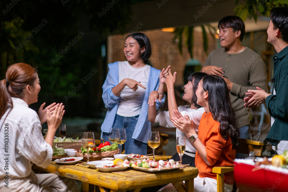 Obraz premium A group of people are gathered around a table with food and drinks