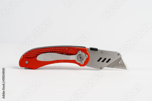 stainless steel folding craft box cutting knife with safety guard and belt clip isolated on a white background photo