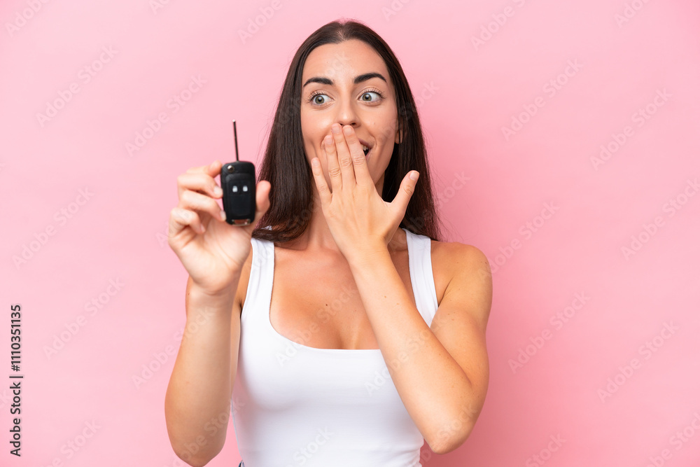 Young caucasian woman holding car keys isolated on pink background with surprise and shocked facial expression Young caucasian woman holding car keys isolated on pink background with surprise and shocked facial expression