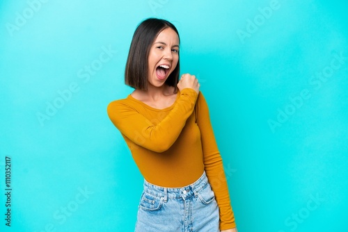 Young caucasian woman isolated on blue background celebrating a victory