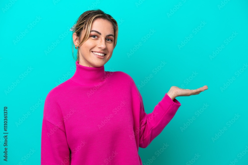 Young caucasian woman isolated on blue background presenting an idea while looking smiling towards Young caucasian woman isolated on blue background presenting an idea while looking smiling towards