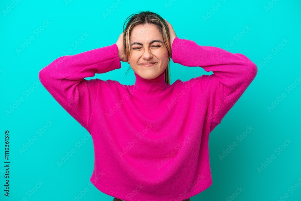 Young caucasian woman isolated on blue background frustrated and covering ears Young caucasian woman isolated on blue background frustrated and covering ears