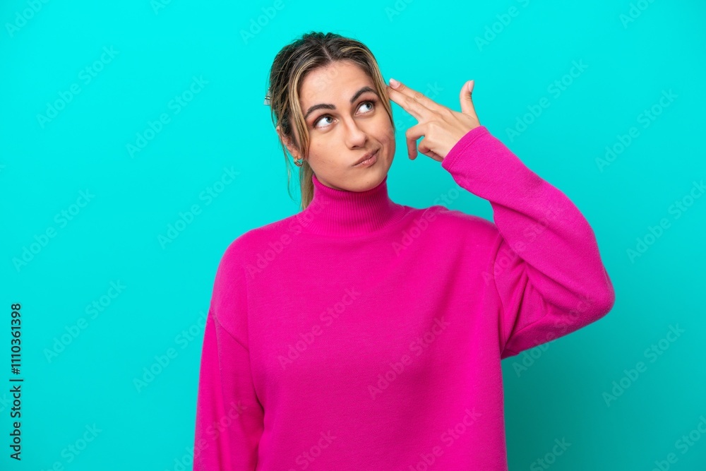 Young caucasian woman isolated on blue background with problems making suicide gesture Young caucasian woman isolated on blue background with problems making suicide gesture
