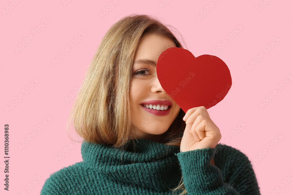 Pretty young woman with paper heart on pink background. Valentine's Day celebration