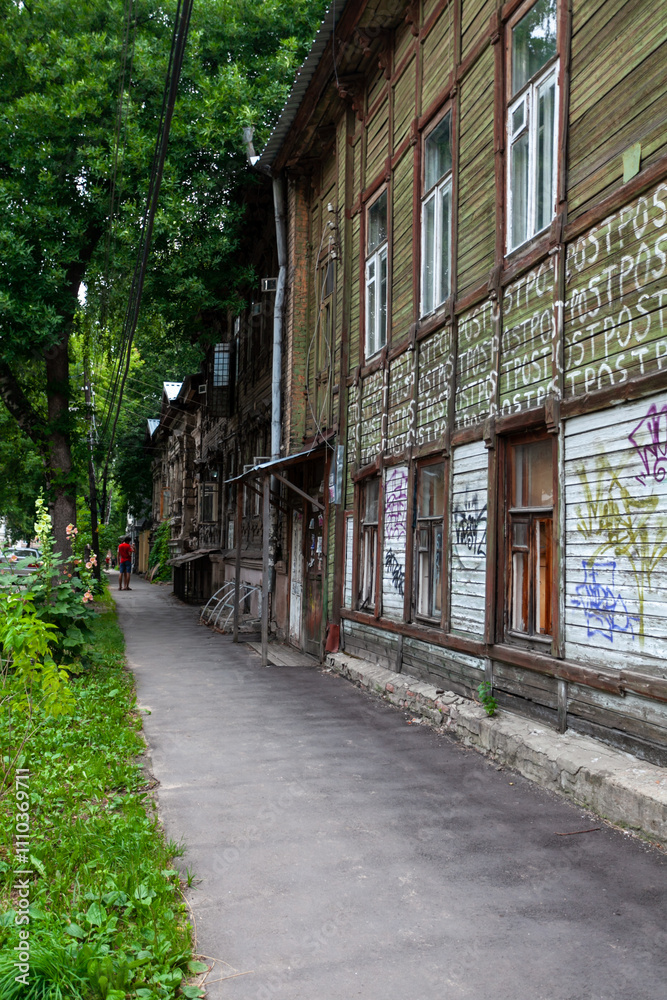 Wandering along a quaint Nizhny Novgorod street, old wooden houses showcase both history and modern art. Wandering along a quaint Nizhny Novgorod street, old wooden houses showcase both history and modern art.