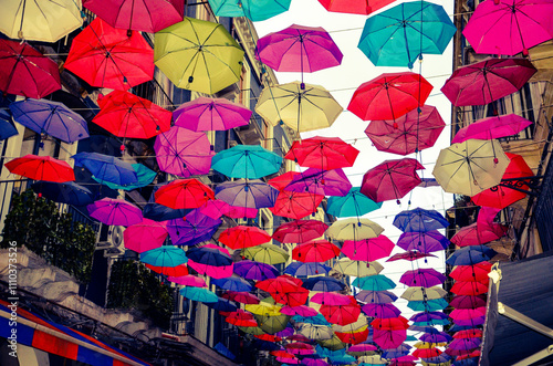 Fototapeta Naklejka Na Ścianę i Meble -  A historic street full of charming restaurants withcolorful umbrellas in Catania
