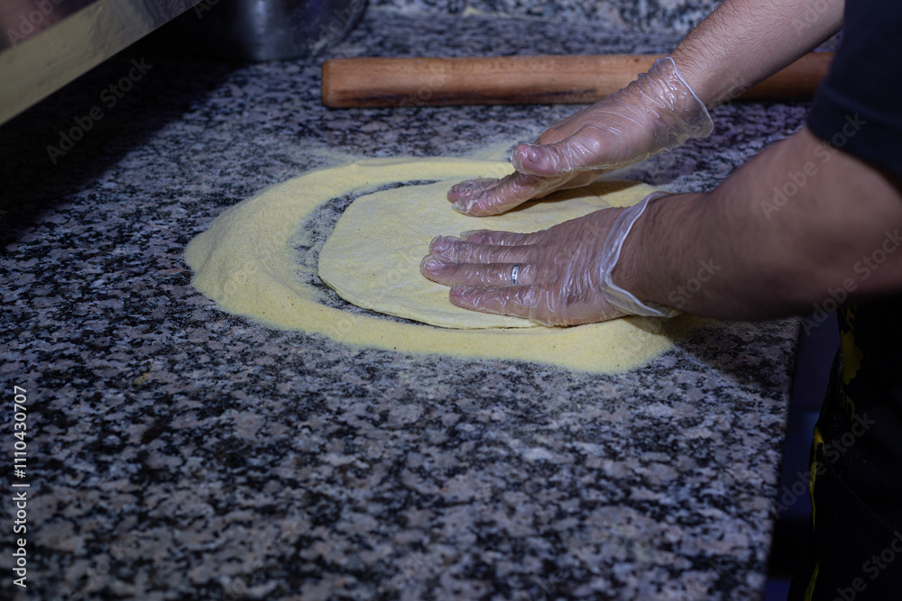 The essence of Italian cuisine captured in a photo: a pizza maker working the dough with passion and precision.