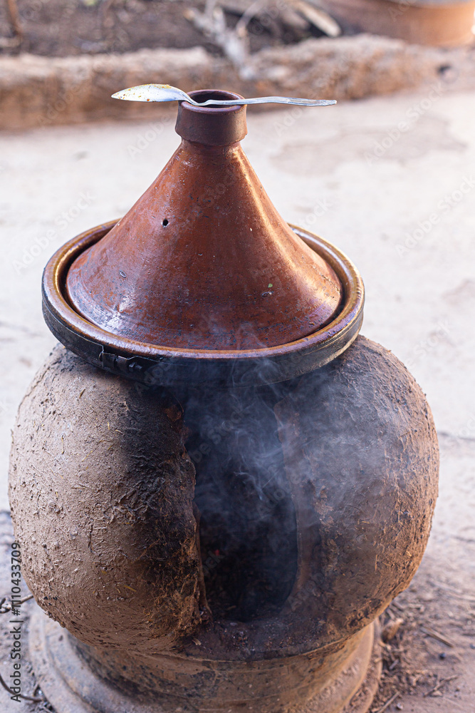 Fire and terracotta: the essence of slow cooking with a tagine in a traditional setting.