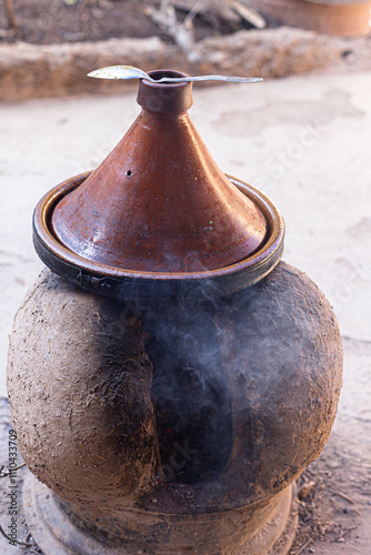 Obraz na płótnie Fire and terracotta: the essence of slow cooking with a tagine in a traditional setting. w salonie