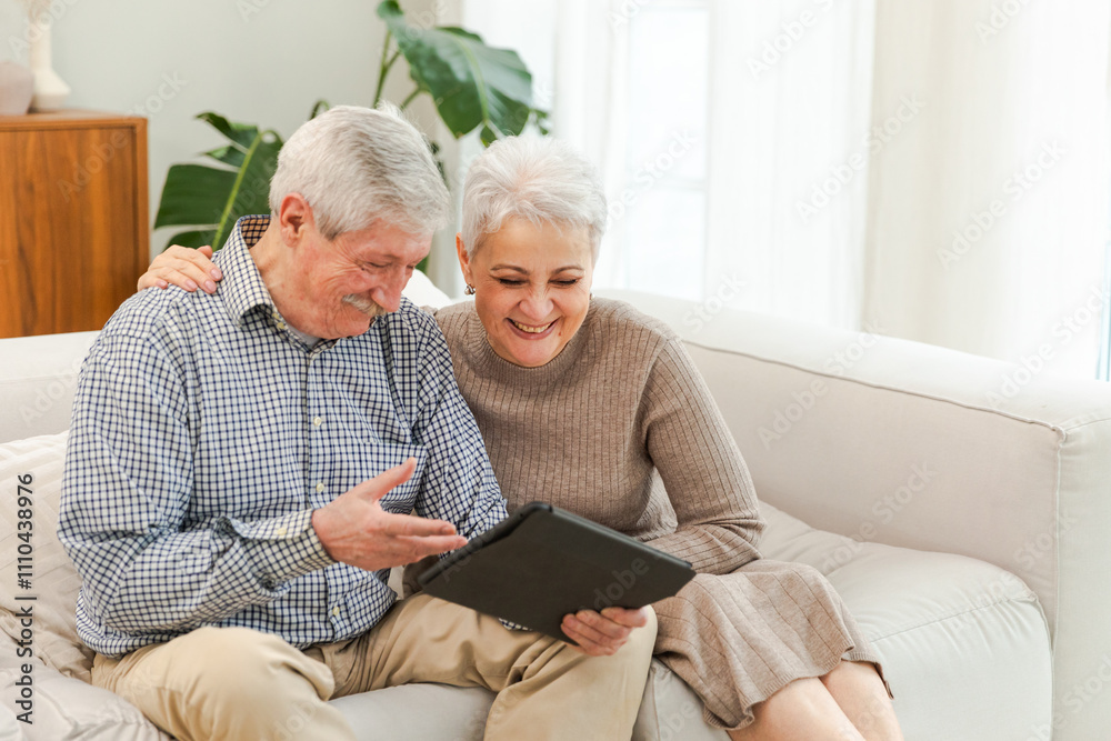 Senior old couple with tablet watching video online. Husband wife spending time together at home. Happy modern mature senior couple using tablet for family entertainment. Old people modern technology Senior old couple with tablet watching video online. Husband wife spending time together at home. Happy modern mature senior couple using tablet for family entertainment. Old people modern technology