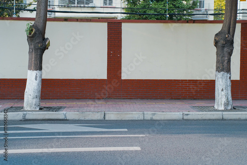 Obraz na płótnie Long old concrete and red brick wall covered with white plaster at city street. Cement fence exterior with copy space and mockup. w salonie