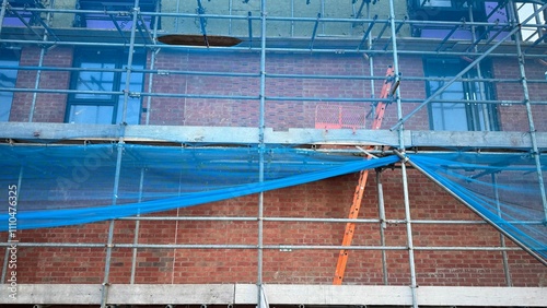 Brick Building Exterior with Scaffolding and Safety Netting