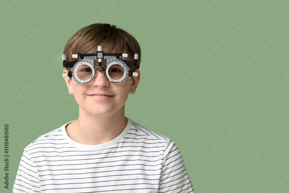 Little boy in optical trial frame on green background Little boy in optical trial frame on green background