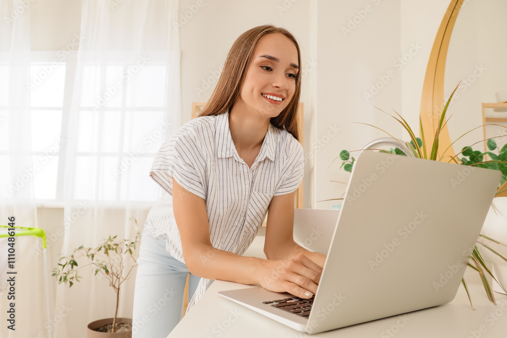 Young woman using laptop on washing machine in bathroom Young woman using laptop on washing machine in bathroom