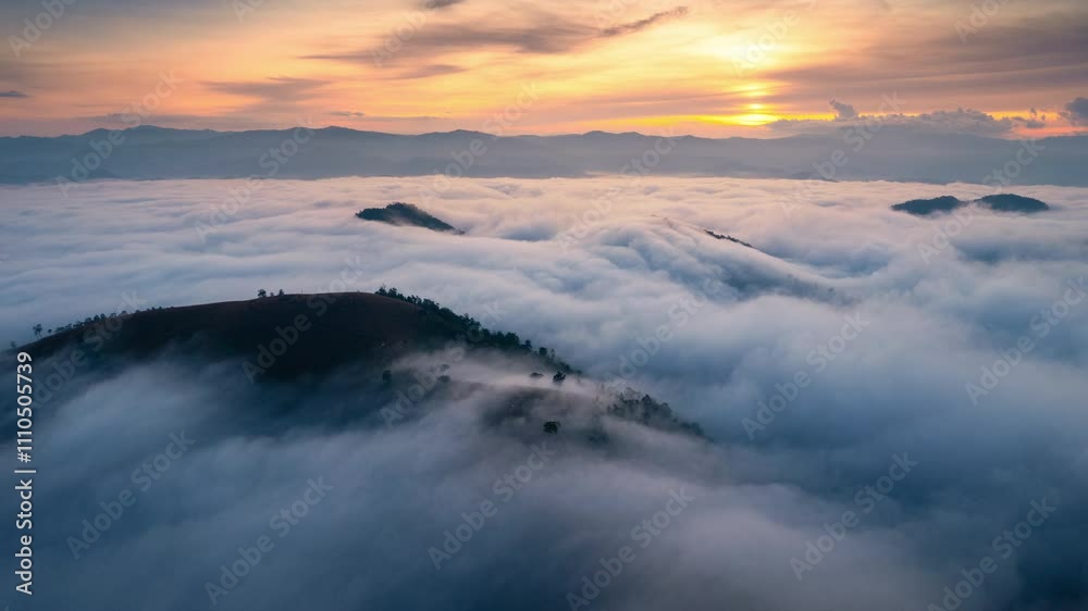 Sea of fog flowing on hill in countryside at sunrise Sea of fog flowing on hill in countryside at sunrise