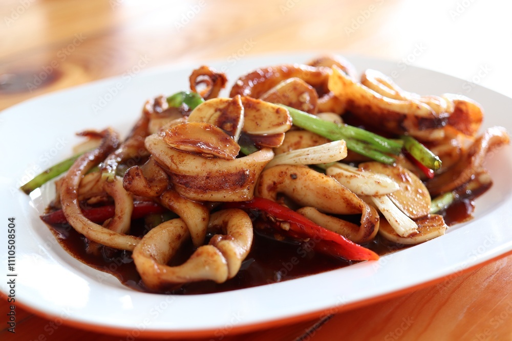 Stir-Fried Squid with Red Curry Paste in white plate, thai food Stir-Fried Squid with Red Curry Paste in white plate, thai food