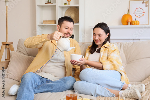 Happy young man pouring tea...