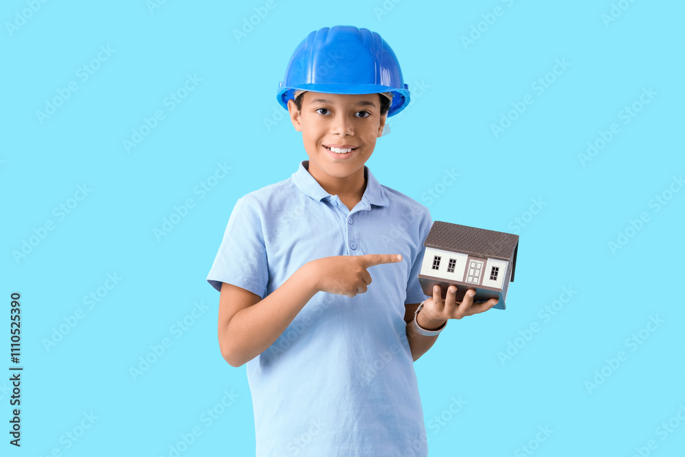 Cute little architect pointing at house model on blue background Cute little architect pointing at house model on blue background