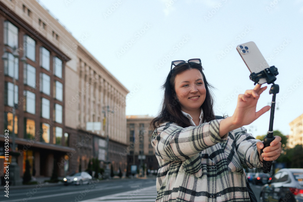 Vlogger traveler woman recording video on phone camera on Khreshchatyk in Kyiv, Ukraine. Gen Z Plus size girl influencer shooting social media stories on the street Vlogger traveler woman recording video on phone camera on Khreshchatyk in Kyiv, Ukraine. Gen Z Plus size girl influencer shooting social media stories on the street